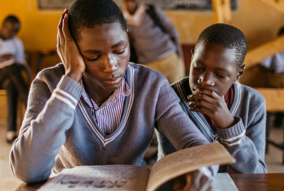 Deux élèves lisent en classe — Accès aux livres en milieu rural Lecture partagée entre deux enfants — soutien scolaire en Afrique rurale